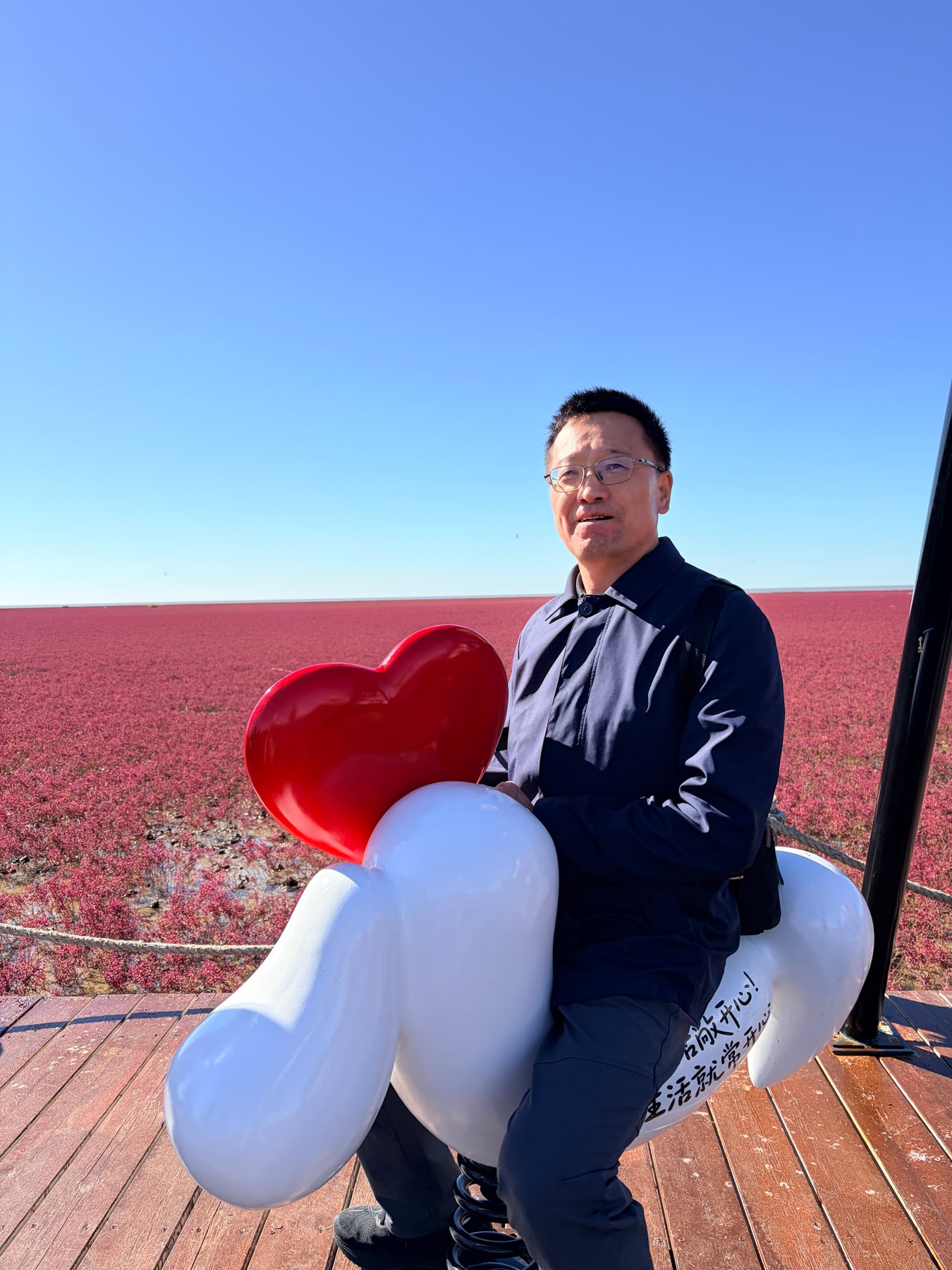 爸爸坐在红心装饰的白色摇摇马上